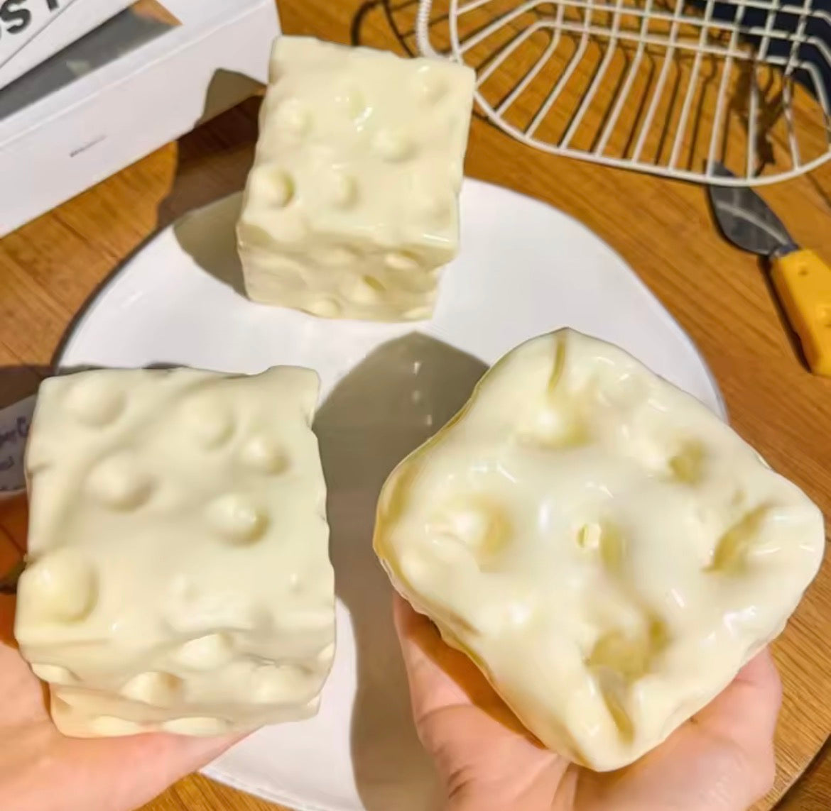 Giant Vaseline cheese squishy shown in hand beside cheese-shaped squishies